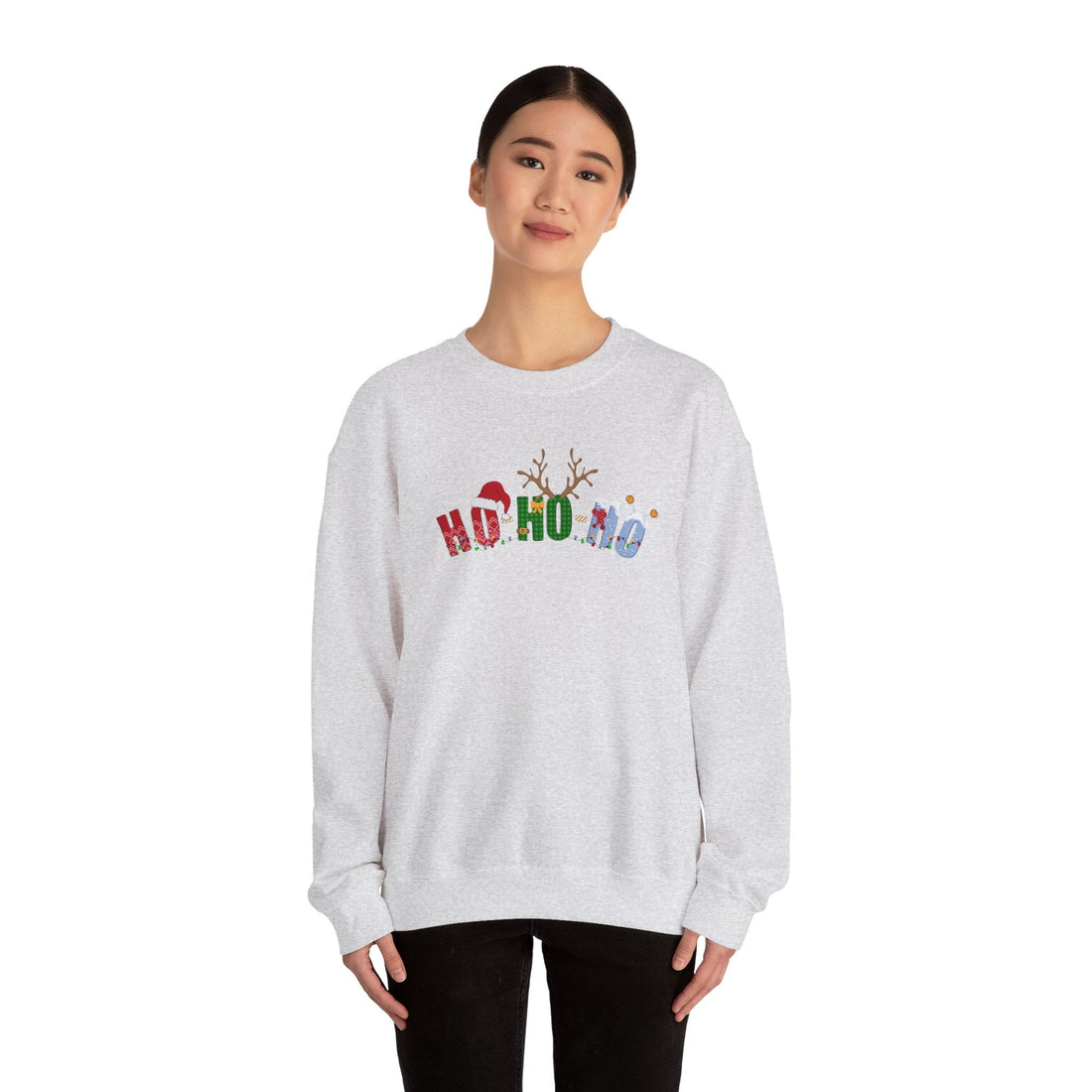 Woman wearing a Ho Ho No Christmas sweatshirt featuring colorful holiday letters with Santa hat and reindeer antlers, funny festive pullover from DJ’s Giggle Wear.